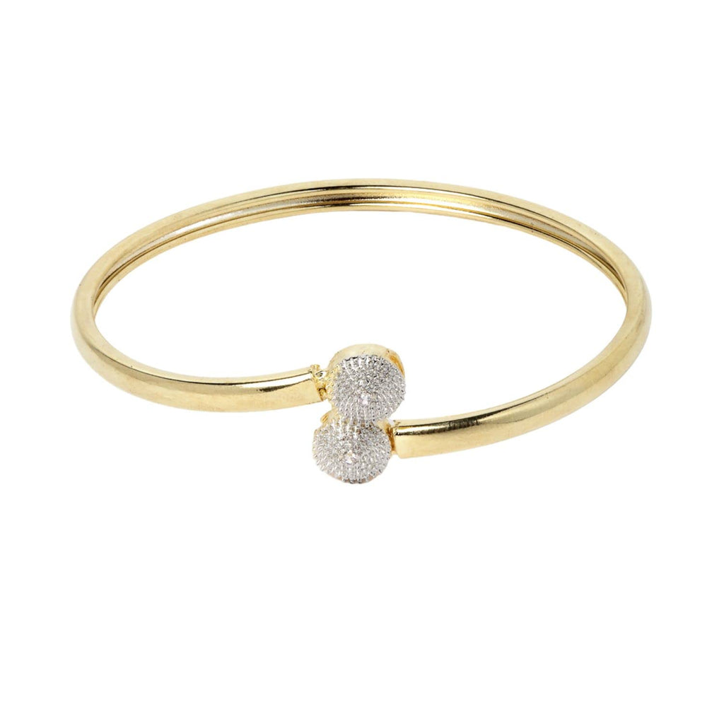 Gold bangle with a silver heart charm on a white background