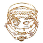 Gold bracelets with various designs on a white background