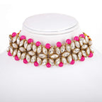 Necklace with pink beads and gold and crystal accents on a white stand