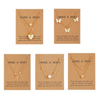 Five gold necklaces with various pendants on brown cards with 'Make a Wish' text.