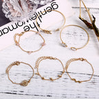 Set of gold bracelets on a white surface with text in the background