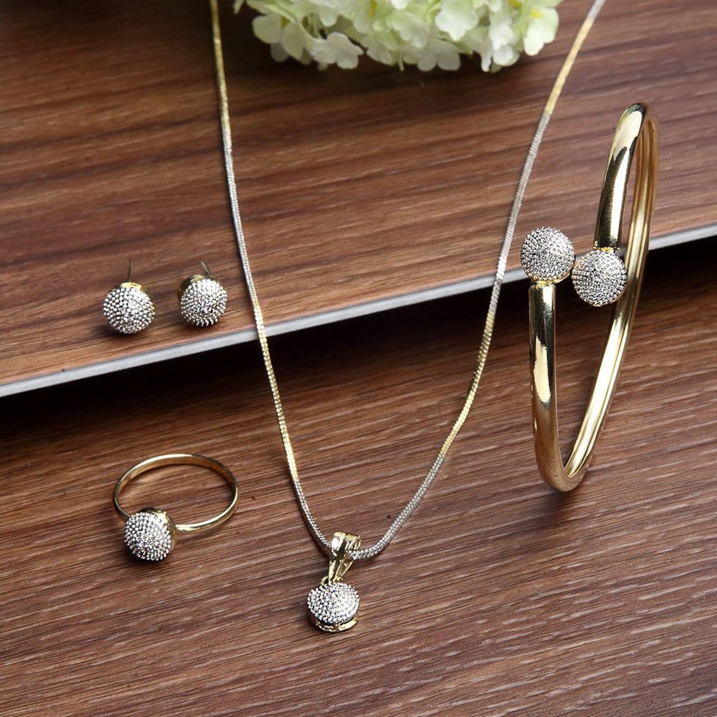 Gold jewelry set including necklace, ring, and earrings on a wooden surface.
