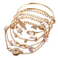 Gold jewelry set with bracelets and necklaces on a white background