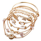 Gold jewelry set with bracelets and necklaces on a white background