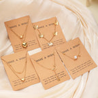 Set of gold necklaces on 'Make a Wish' cards with decorative elements.