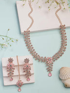 Pink jewelry set with necklace and earrings on a light blue background