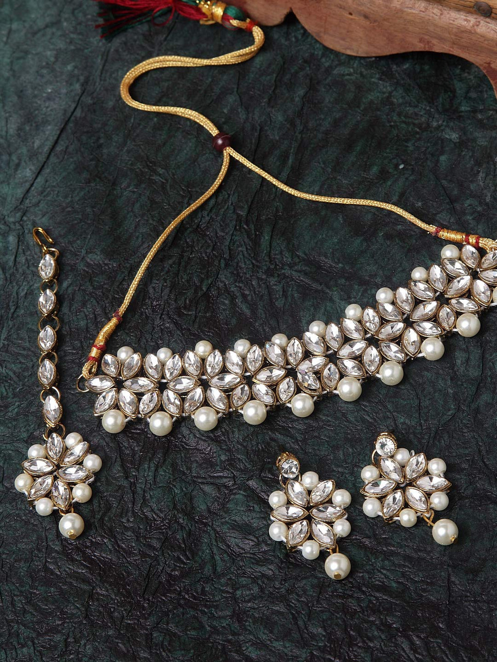 Jewelry set with necklace, earrings, and bracelet on a dark textured surface